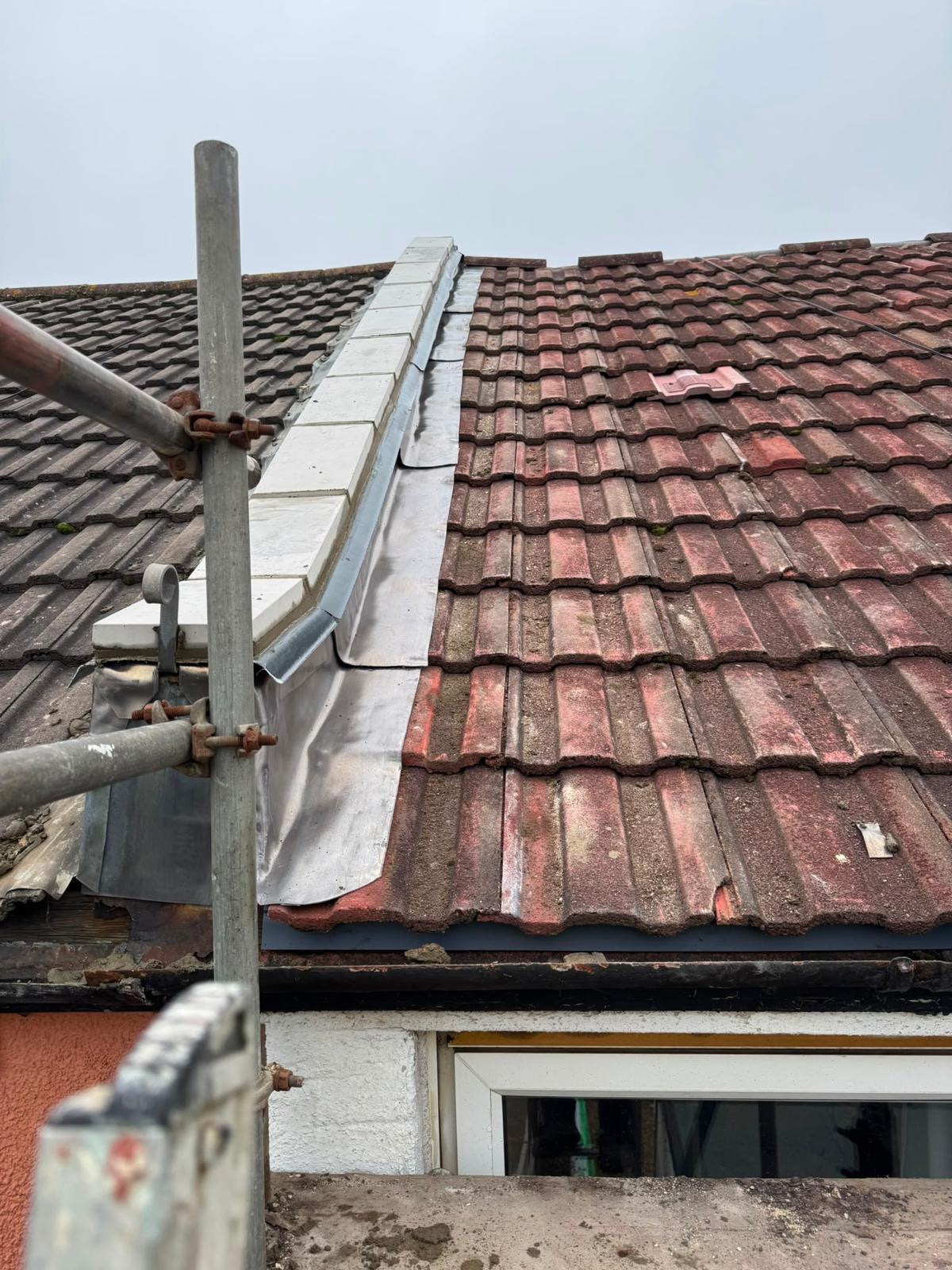 Lead flashing along a tiled roof junction